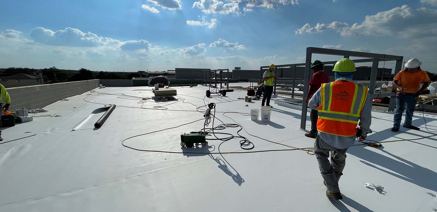 roofers on top of commercial building